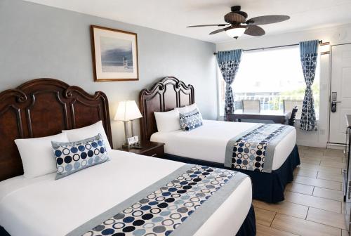 a hotel room with two beds and a window at Sunset Beach Hotel in Wildwood
