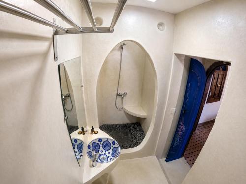a bathroom with a sink and a mirror at Riad Zaitouna Chaouen in Chefchaouen