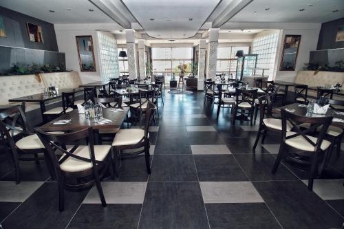 a dining room with tables and chairs in a restaurant at Hotel Costa Marfil Baquedano in Antofagasta