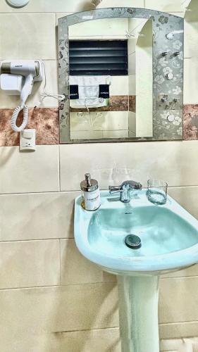 a bathroom with a blue sink and a mirror at Mi Refugio 1 in Río San Juan