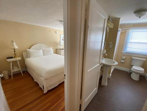 a bedroom with a white bed and a sink at The Kennebunk Inn in Kennebunk