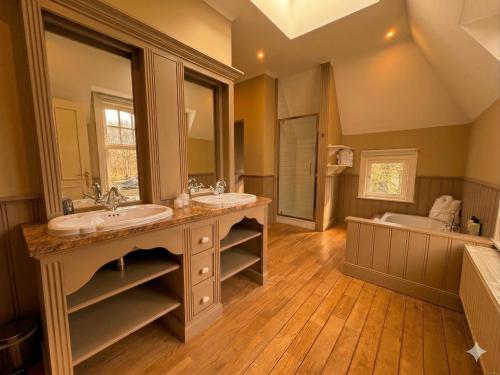 a large bathroom with two sinks and a tub at Le Manoir des Etangs in Etbos