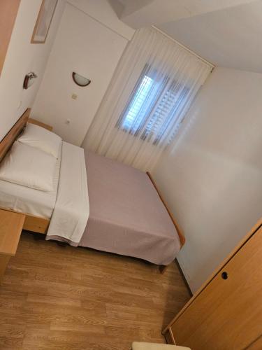 a small bedroom with a bed with a window at Apartman Bruna in Novigrad Istria