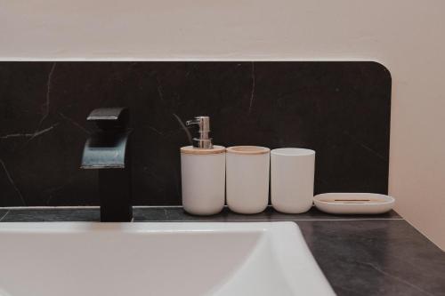 a bathroom with three white cups and a sink at Casa Antonio Mazunte in Mazunte
