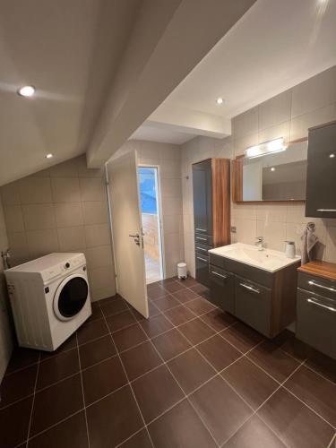 a bathroom with a washing machine and a sink at Helles, großzügiges Loft mit Fernblick in Siegendorf im Burgenland
