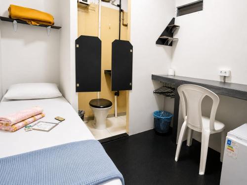 a room with a bed and a desk and a chair at Solar Clefis in Vitória