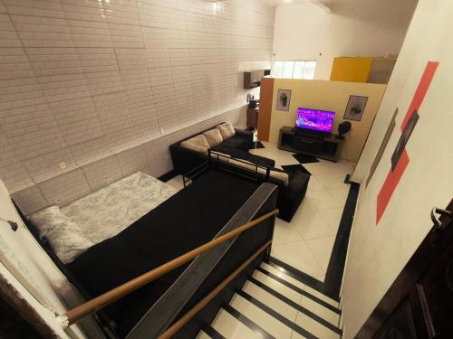 a room with a staircase with a couch and a television at Diadema Studio - Apt 11 in Diadema