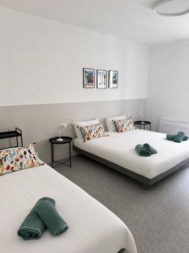 a room with two beds and two tables at Dietro le Quinte Rho Apartments in Rho