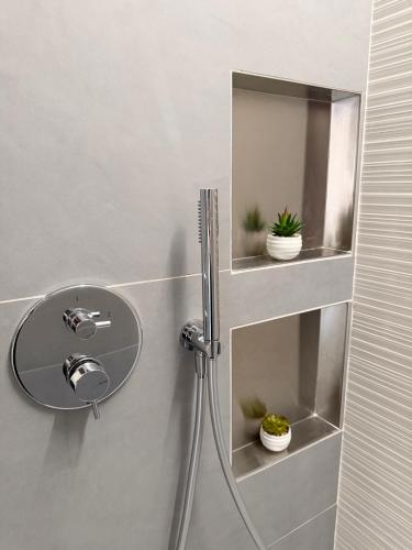 a bathroom with a sink and a shelf with plants at Dietro le Quinte Rho Apartments in Rho