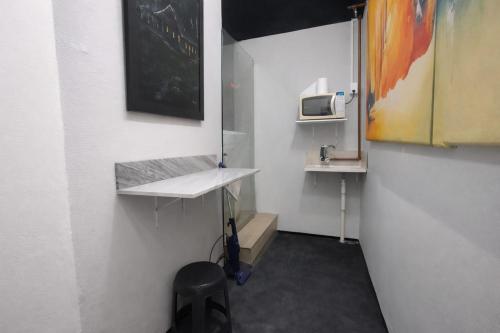 a small bathroom with a sink and a microwave at Solar Clefis in Vitória