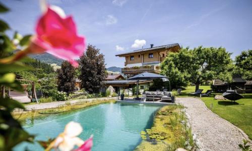 a swimming pool with a house in the background at Chalets Wagrain in Wagrain