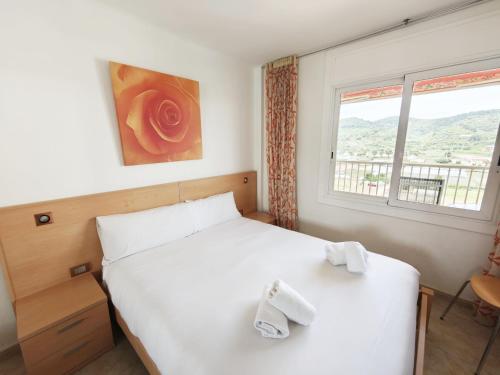 a bedroom with a white bed and a window at Sea&Kids in Malgrat de Mar