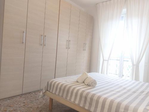 a bedroom with a bed with white cabinets and a window at Milan Top-Floor Flat City View 2 Balconies Workspace M5 in Milan
