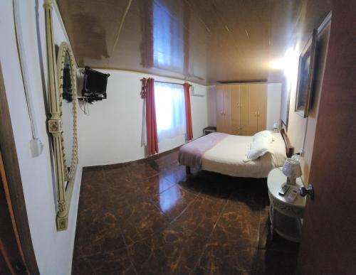 a small bedroom with a bed and a window at La Quimera a pasos de la playa in Atlántida