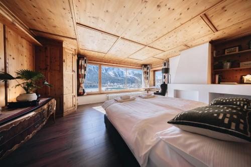 a bedroom with a large bed and a large window at Villa Beaulieu in St. Moritz
