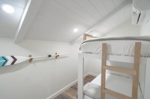 a bunk bed in a white room with a ladder at 401 Maalaea Banyans in Wailuku
