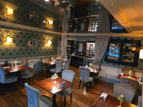 a restaurant with tables and chairs in a room at The White House in Kinsale