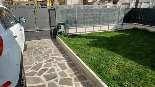 a white car parked next to a yard with grass at il Biscottino in Castel di Sangro