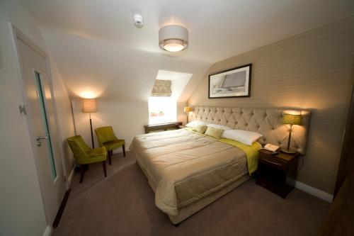 a bedroom with a bed and a table and a chair at The White House in Kinsale