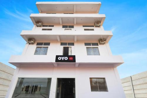 a white building with a qo sign on it at Hotel O Radha Krishna Residency in Nagri