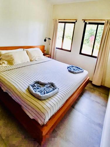 a bedroom with a bed with two towels on it at Tierra Encantada in Dominicalito