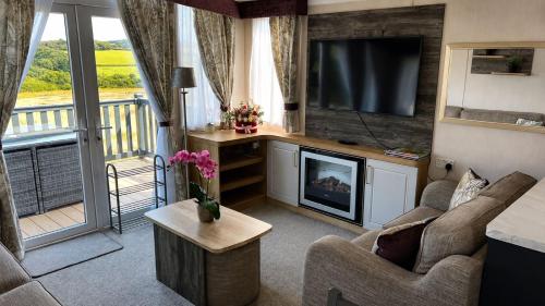 a living room with a flat screen tv and a couch at 14B Medina Rise Ferry Offers Available in Porchfield