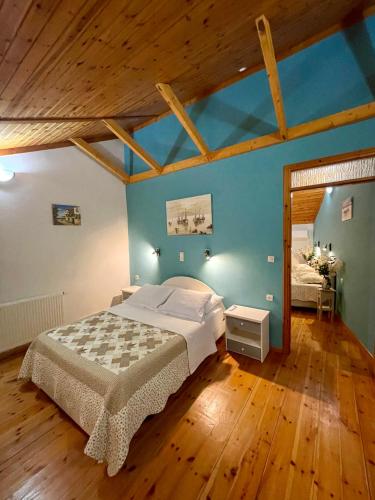 a bedroom with a large bed in a room with wooden floors at Starvillas Apartments and Studios in Agia Effimia