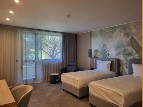 a hotel room with two beds and a window at Tsarsko Selo Spa Hotel in Sofia