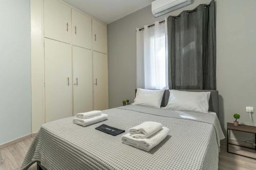 a bedroom with a bed with towels on it at Gkr Luxury Apartments Metro Petralona in Athens