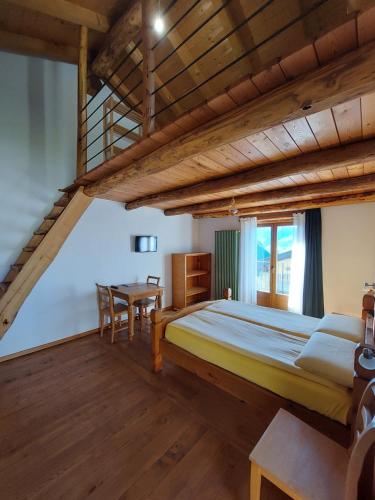 a bedroom with a loft bed and a table at Agriturismo Zertin in Gravedona