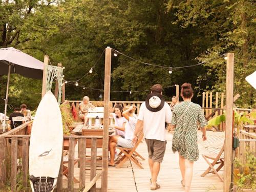 a group of people walking on a wooden deck at Aparra Surfcamp Auberge Hendaye in Hendaye