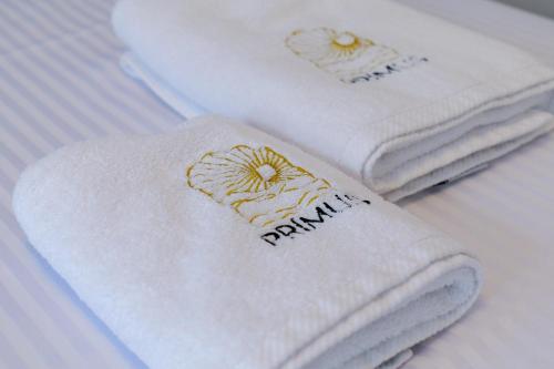 three towels sitting on top of a bed at Hotel Sea View Shëngjin in Lezhë