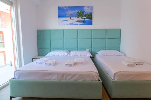 two beds sitting next to each other in a bedroom at Hotel Sea View Shëngjin in Lezhë