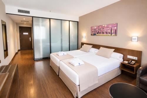 a bedroom with a large white bed and a couch at ARVA Abad San Antonio in León