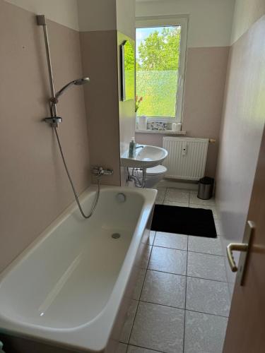 a bathroom with a large tub and a sink at Fewo Am Poetenteich in Jänkendorf