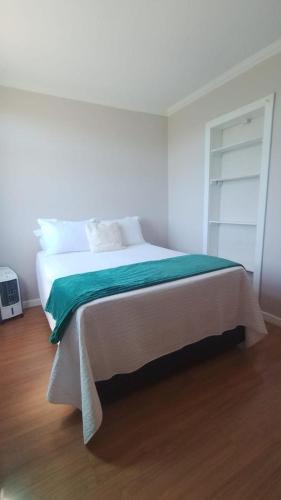 a bedroom with a bed with a green blanket on it at Refúgio da praia in Serra