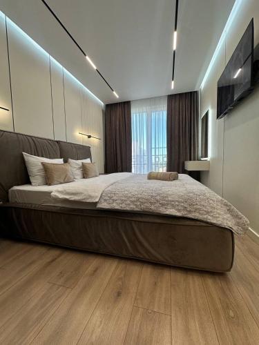a large bed in a bedroom with a large window at Euroconfort Ciocana Apartment Exfactor 6 in Chişinău