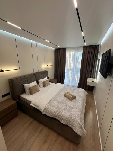 a bedroom with a large bed and a large window at Euroconfort Ciocana Apartment Exfactor 6 in Chişinău