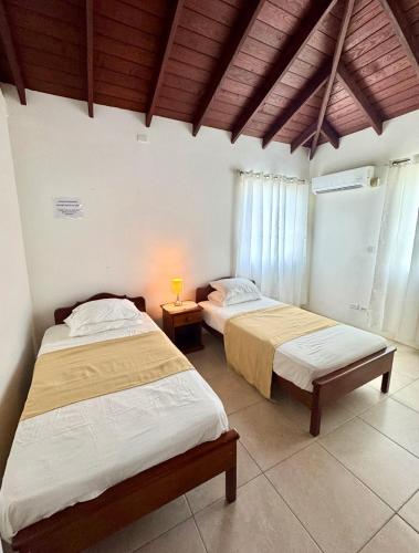 a bedroom with two beds and a lamp on a table at Claraville Apartment - Unit 2 in Saint James