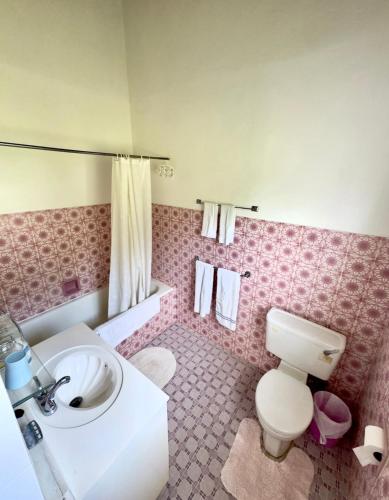 a pink bathroom with a toilet and a sink at Claraville Apartment - Unit 2 in Saint James