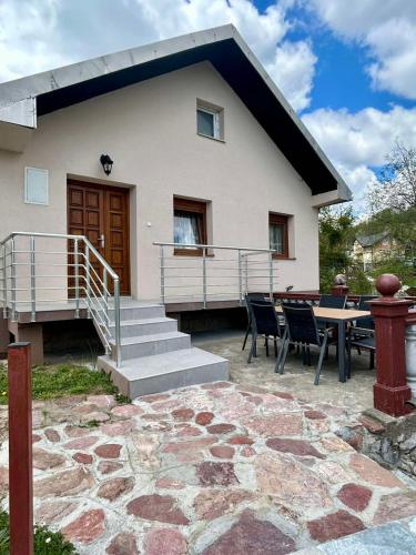 a house with a patio and a table and chairs at Mont Peak Apartment in Kolašin