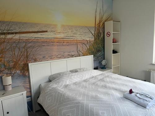 a bedroom with a bed with a painting of a beach at De Groene Oase in Harkstede