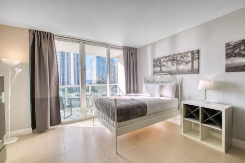 a bedroom with a bed and a large window at MIAMI Collins Beach Apartments in Sunny Isles Beach