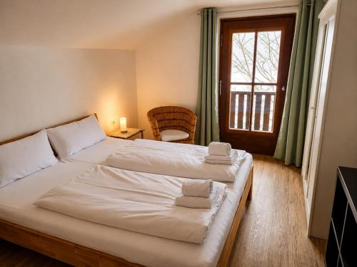 a bedroom with a large white bed and a window at Horner Viehweid in Schwangau
