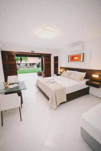 a large bedroom with two beds and a table at Casa Kite Academy in Caucaia