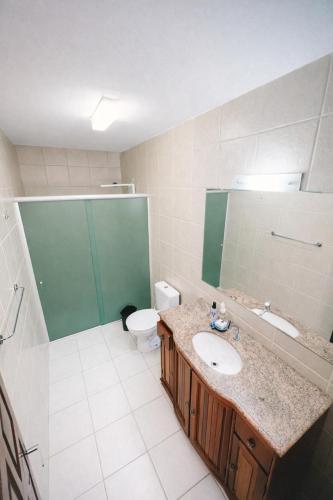 a bathroom with a sink and a toilet and a mirror at Casa Kite Academy in Caucaia