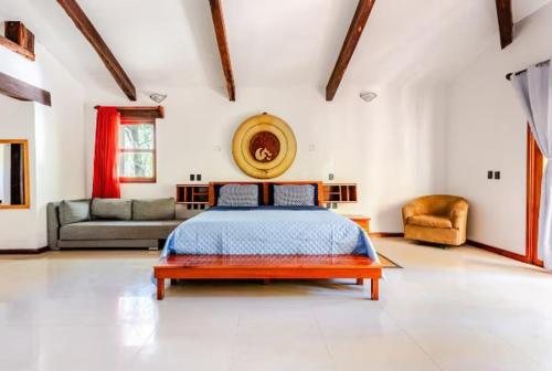 a large bedroom with a bed and a couch at Villa con piscina y acceso a laguna Yalku, Akumal in Akumal