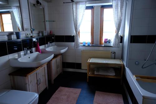 a bathroom with two sinks and a tub at Judies Garten in Füsing
