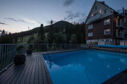 a large swimming pool on a deck next to a building at Hotell Fjällgården Ski-In Ski-Out in Åre