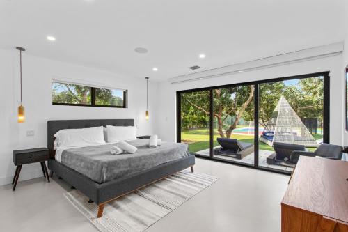 a bedroom with a bed and a large window at Platinum Villa w Karaoke, Pickleball, BKB & Soccer in Davie